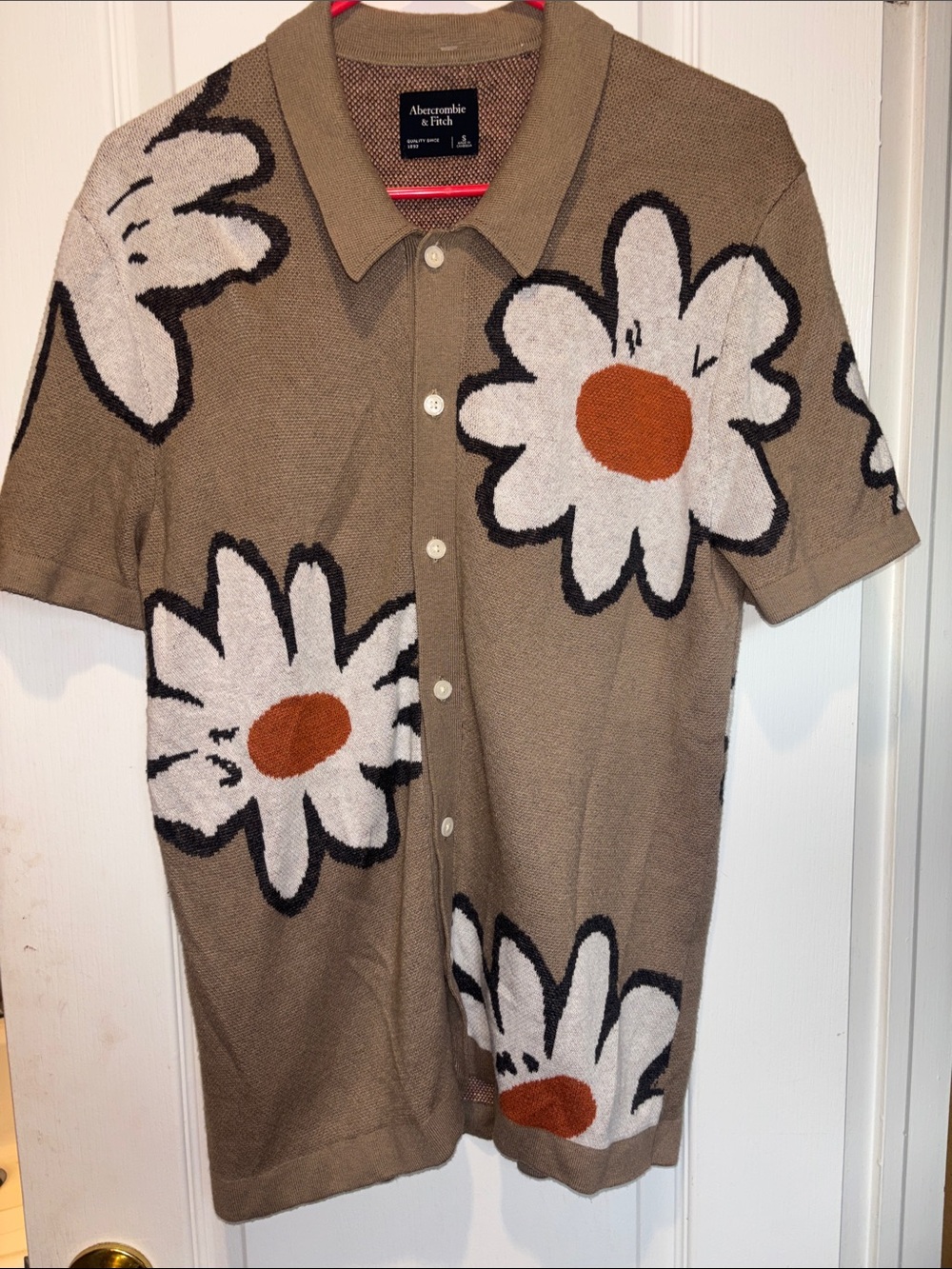 ABERCROMBIE & FITCH TAN WITH A WHITE DAISY KNIT BUTTON DOWN SHORT SLEEVES
UNISEX